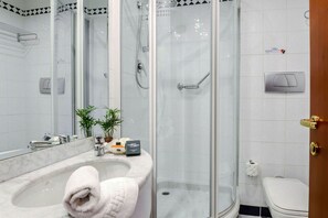 Enjoy a refreshing shower in the bathroom, featuring a glass-enclosed shower with a handheld showerhead and a handheld faucet.