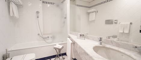 A modern bathroom with a large bathtub, a separate shower area, and a toilet.