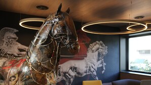 A modern interior with a decorative horse sculpture, contemporary seating, and a mural of horses. - Cavallo Hotel Verona Est (Verona)