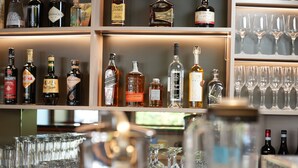 A bar area with shelves of liquor bottles and glasses. - Cavallo Hotel Verona Est (Verona)
