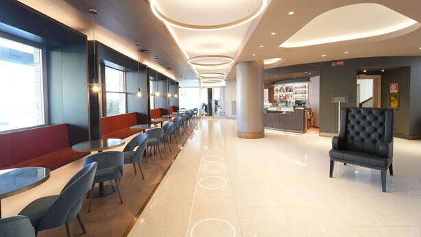 A modern restaurant with a long counter, multiple seating areas, and a bar. - Cavallo Hotel Verona Est (Verona)
