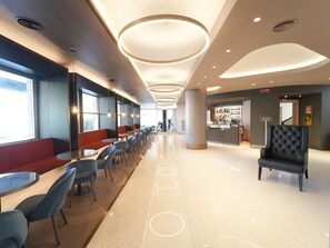 A modern restaurant with a long counter, multiple seating areas, and a bar. - Cavallo Hotel Verona Est (Verona)