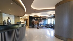 A modern reception area with a reception desk, a large horse sculpture, and a mural on the wall. - Cavallo Hotel Verona Est (Verona)