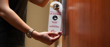 Una persona sosteniendo un cartel de alquiler de cámaras en la puerta de un hotel.