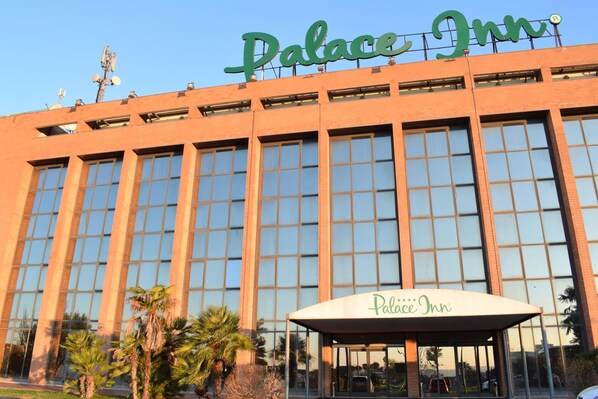 A large building with a sign reading 'Palace Inn' at the top.