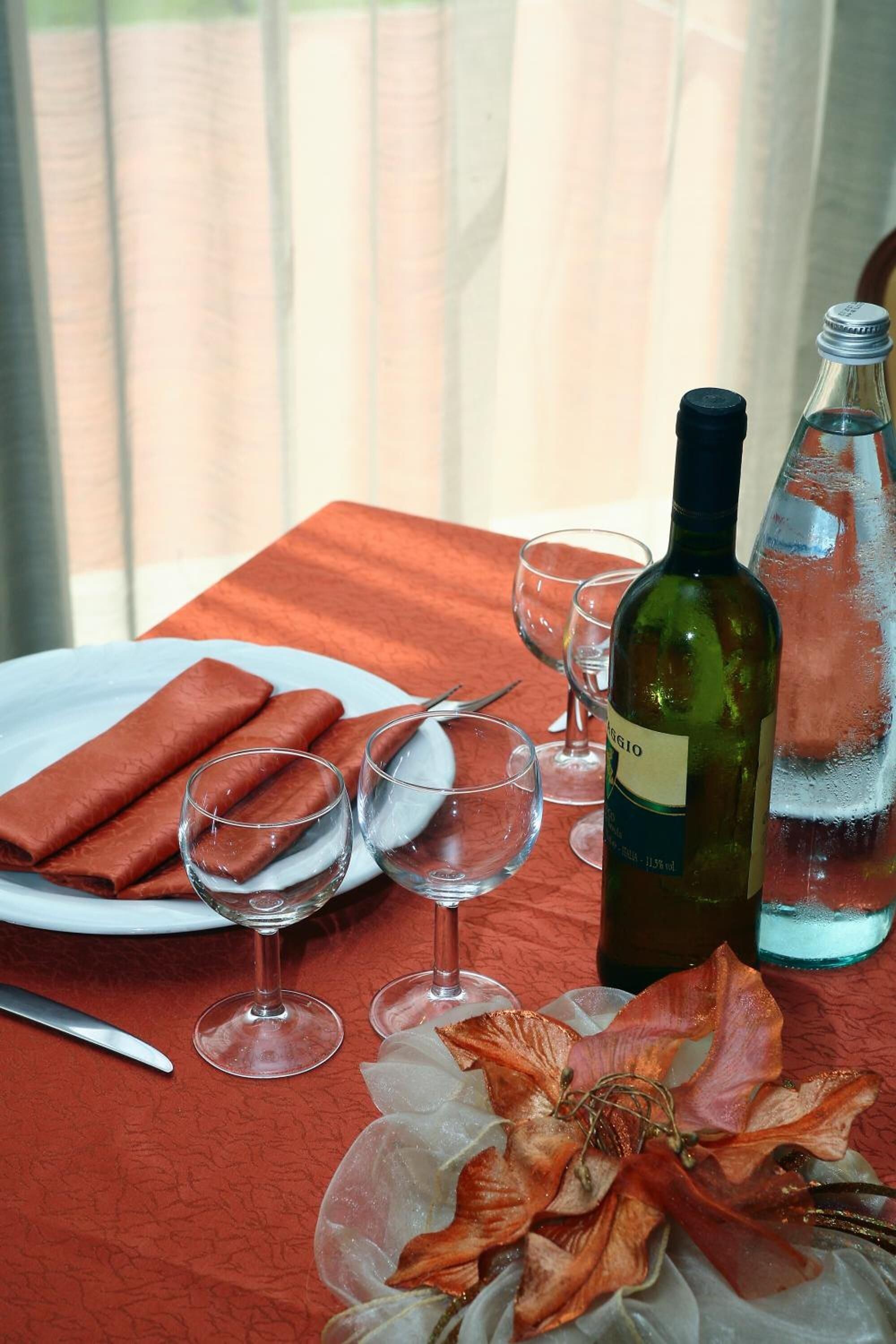 Ein Tisch mit einer Weinflasche, Gläsern und einem Teller mit Essen.