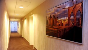 A hotel hallway with a large framed picture of a bridge and cityscape on the wall. - Palace Inn (Fiano Romano)