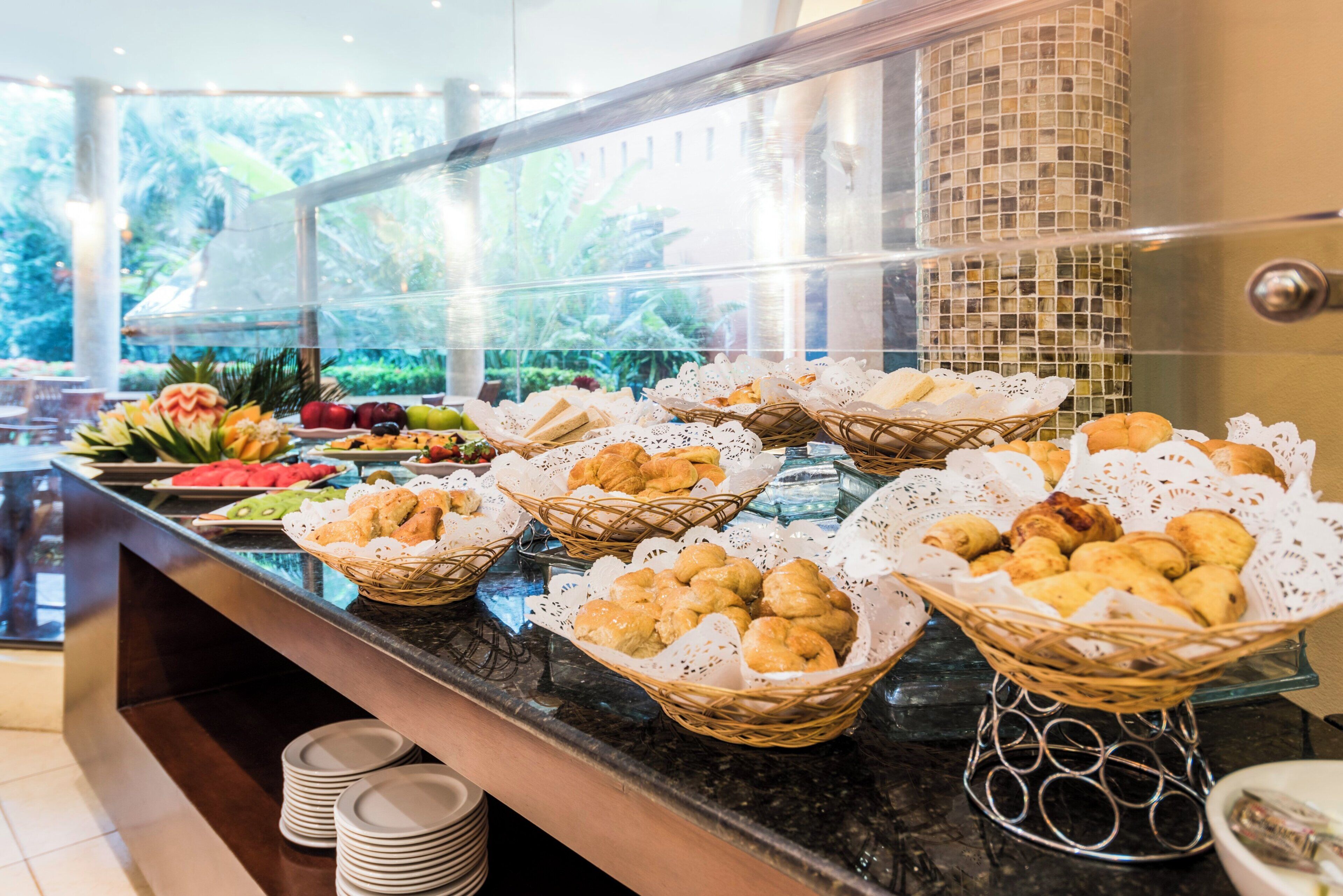 Un buffet proposant une variété de plats et des paniers remplis de viennoiseries.