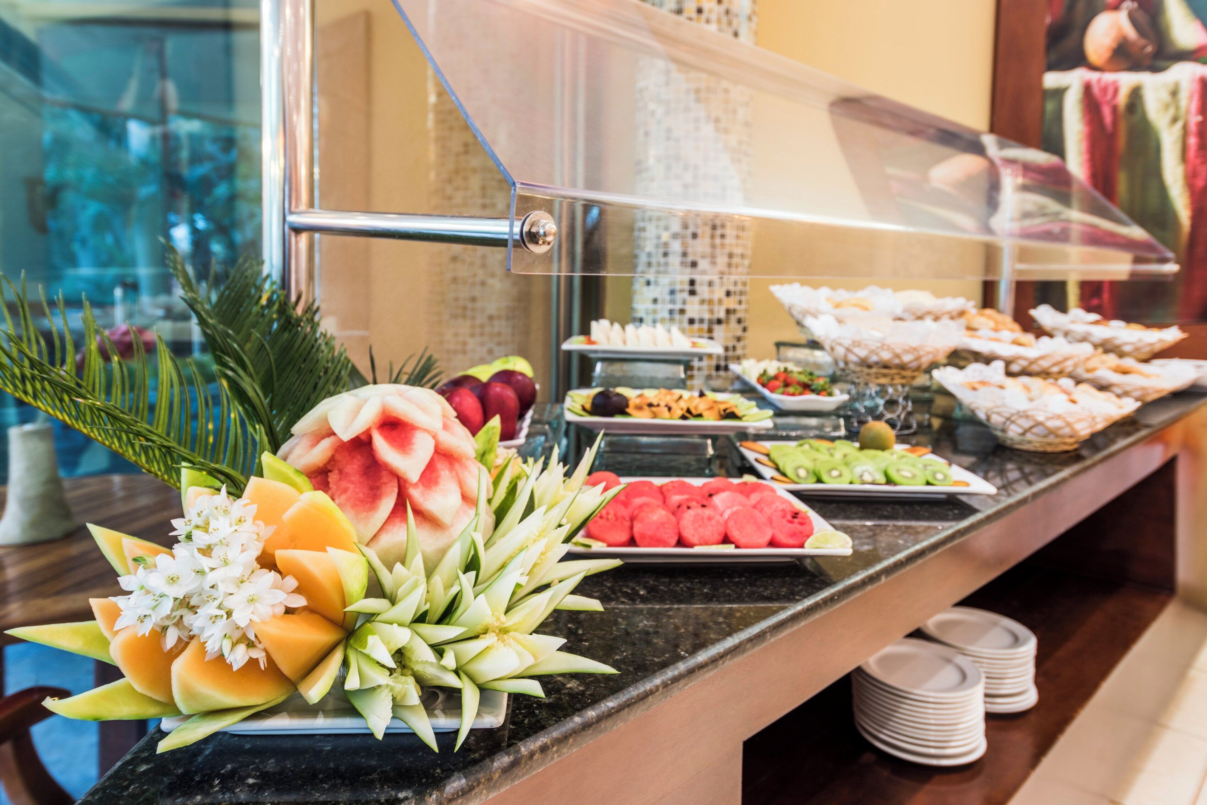 A buffet with various fruits and pastries.