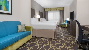 A hotel room with a bed, a blue sofa, a desk, and a television. - Holiday Inn Express & Suites Ames by IHG (Ames)