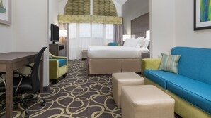 A hotel room with a bed, a desk, a chair, a sofa, and a TV. - Holiday Inn Express & Suites Ames by IHG (Ames)