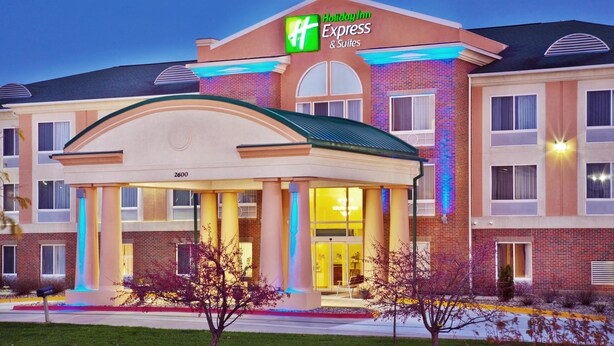 A Holiday Inn Express & Suites building with a covered entrance, brick facade, and illuminated signage. - Holiday Inn Express & Suites Ames by IHG (Ames)