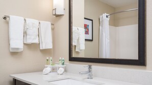 A modern bathroom with a white sink, a large mirror, and white towels hanging on a rack. - Holiday Inn Express & Suites Ames by IHG (Ames)