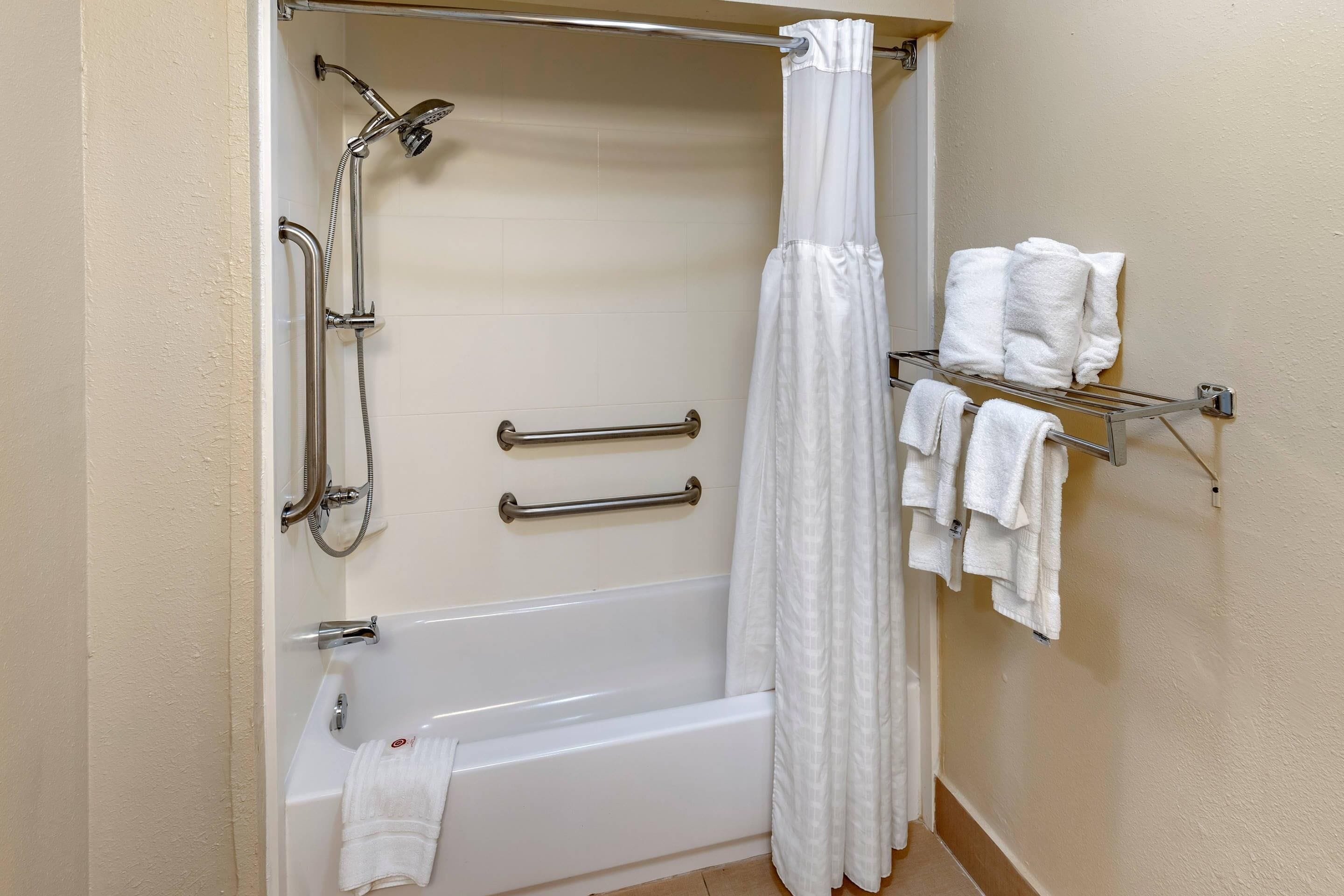 A bathroom with a bathtub, shower, and towel rack.