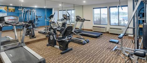 A gym with treadmills, elliptical machines, and weight equipment.