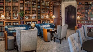 A library with bookshelves, sofas, and tables. - De Vere Tortworth Court (Wotton-under-Edge)