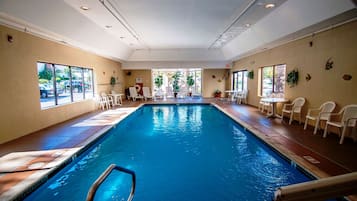 Una piscina techada, sillones reclinables de piscina