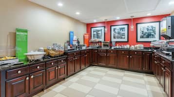Una cocina amplia con armarios de madera, una isla grande y una pared de acento roja.