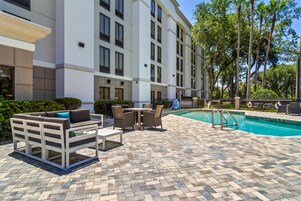 Una piscina al aire libre, sillones reclinables de piscina