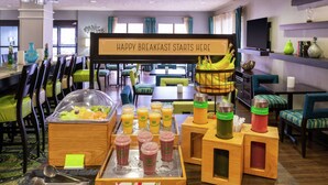 A breakfast buffet with various fruit options and juices.