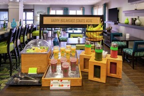 A breakfast buffet with various fruit options and juices.