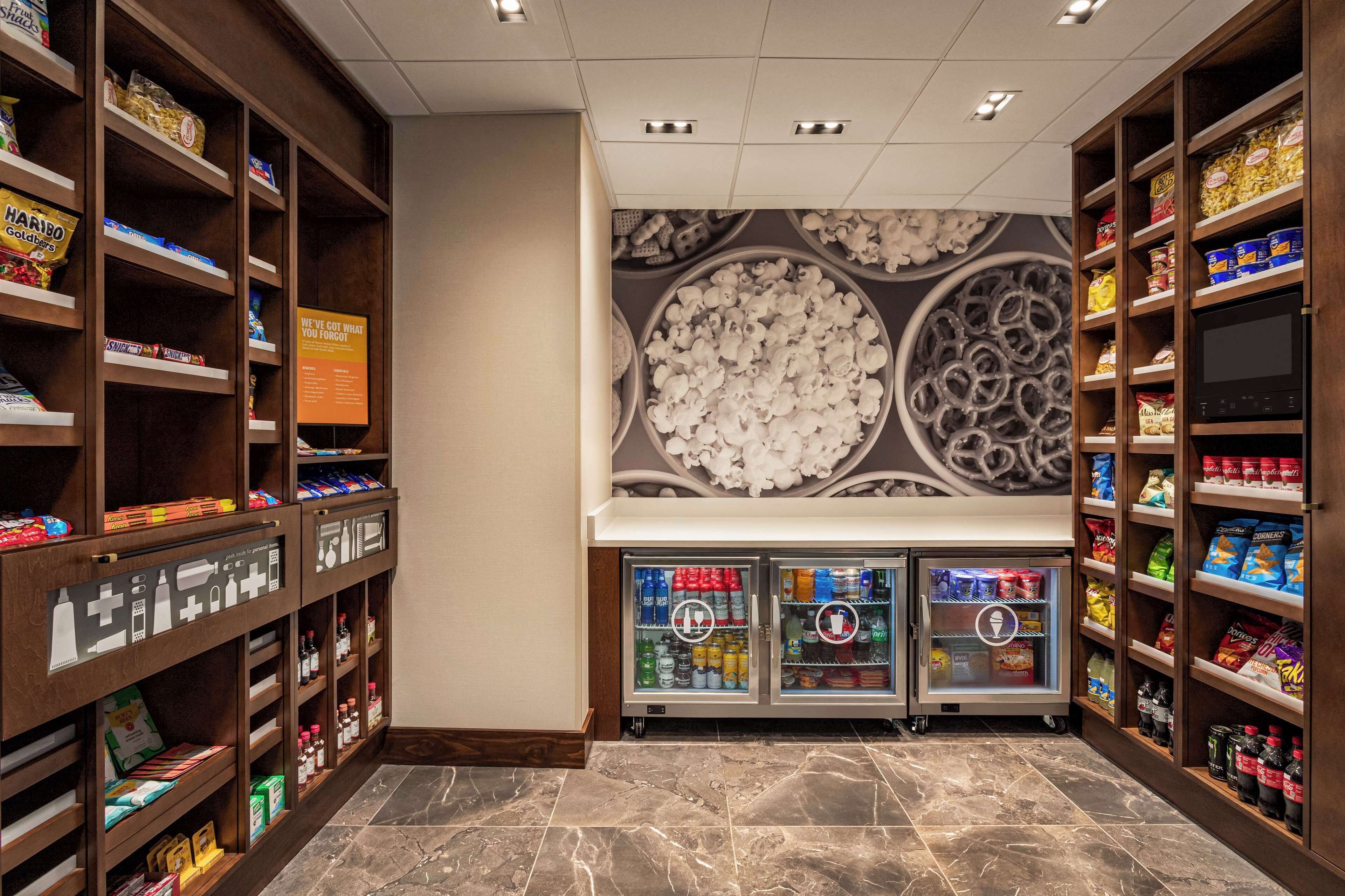A well-stocked snack and beverage area with shelves and freezers, featuring a variety of snacks and drinks.