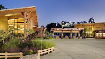 A zoo entrance with a wooden facade, large windows, and a sign for Riverbanks Zoo and Garden.