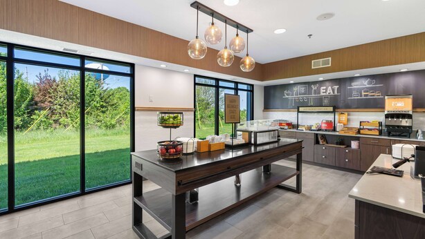 A modern kitchen with large windows, a buffet counter, and a chalkboard menu. - Hampton Inn Ottawa (Starved Rock Area) (Ottawa)