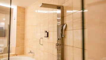 Une salle de bain moderne équipée d’une baignoire, d’une douche avec un pommeau de douche amovible et d’un robinet mural.