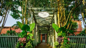 A covered walkway leading to a building with a sign reading "Crea 1886 Restaurant".