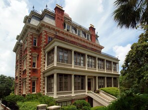 A large, historic building with multiple stories, featuring a prominent balcony and a grand staircase leading to the entrance. - Wentworth Mansion (Charleston)