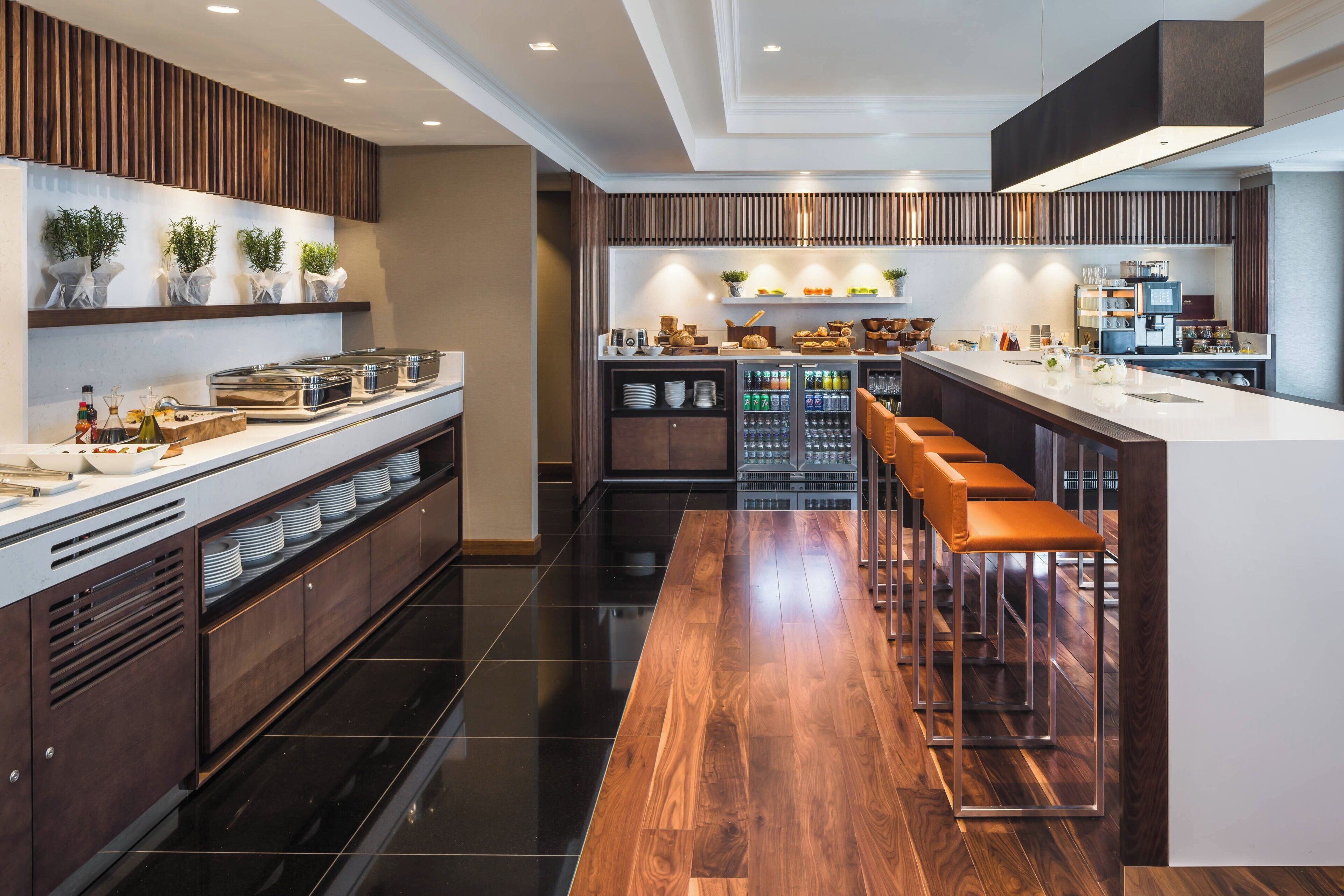 Una cocina moderna con una isla central, taburetes de bar y una variedad de electrodomésticos.