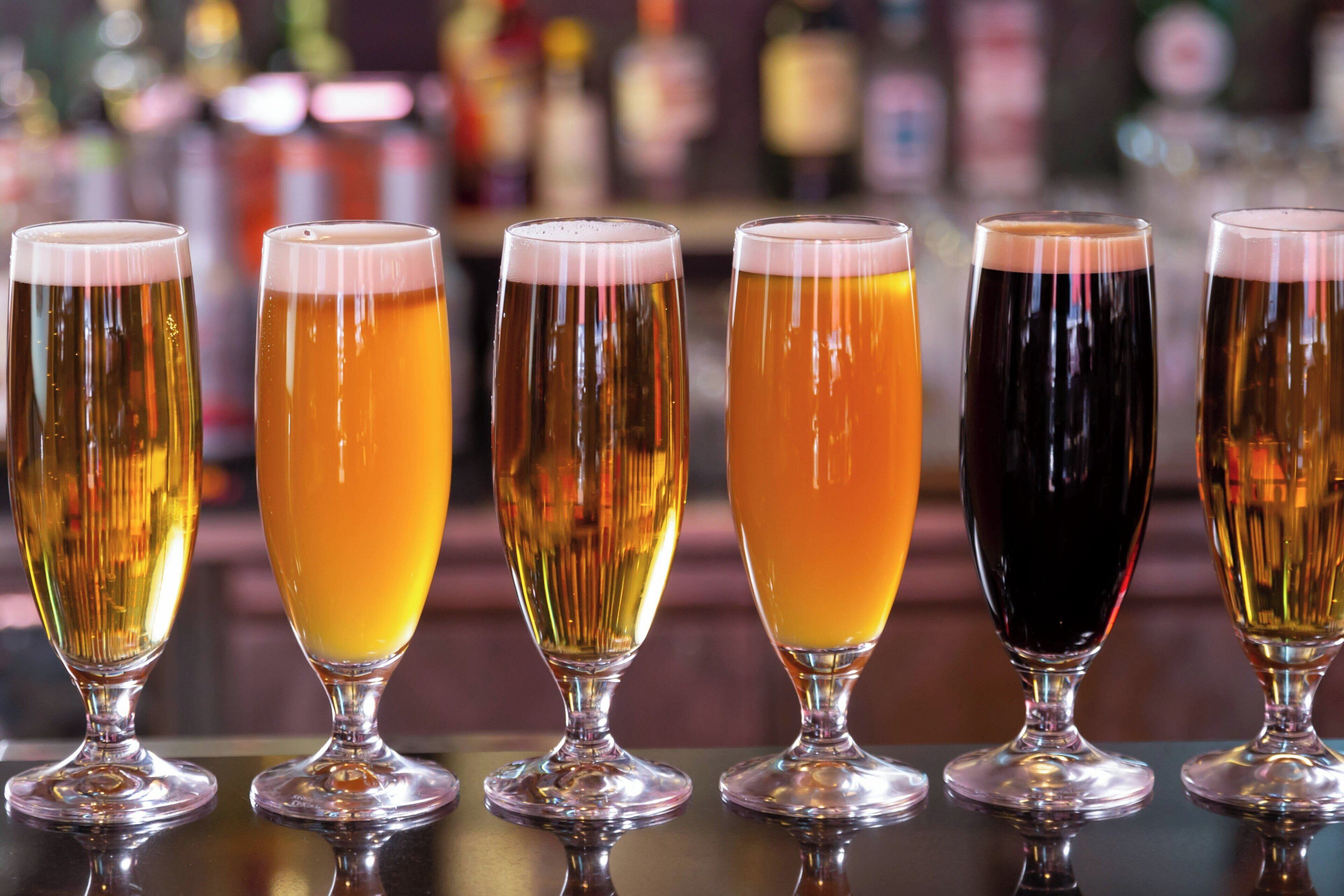 Six verres de bière sur le comptoir d’un bar.