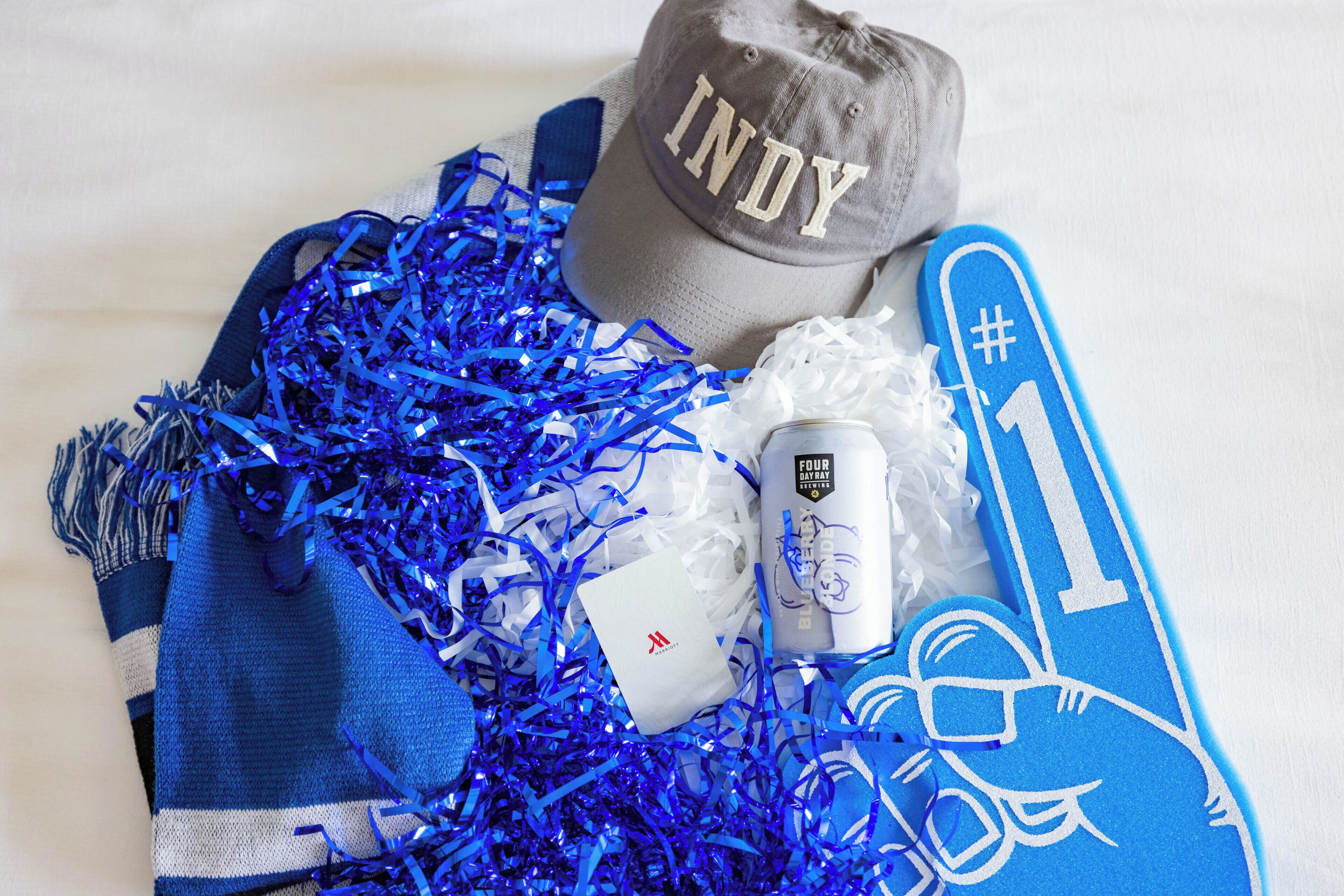 A collection of sports memorabilia, including a cap, a scarf, and a foam finger.