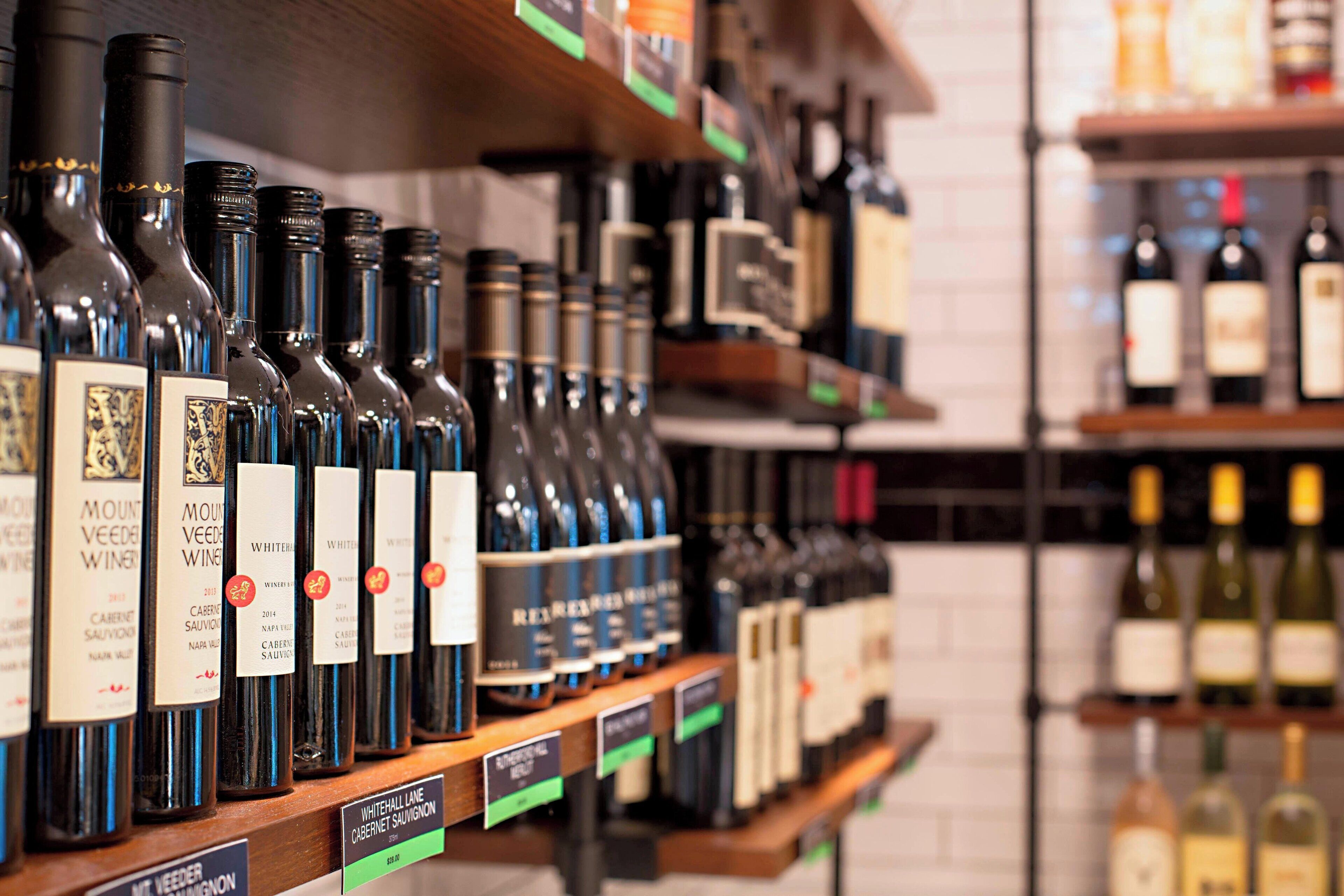 Una estantería con diferentes botellas de vino, incluyendo variedades blancas y tintas.