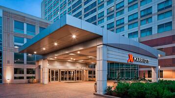 A Marriott hotel entrance with a modern design, featuring a prominent entrance, large windows, and a well-lit facade.