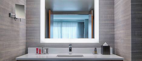 A modern bathroom with a large mirror, a sink, and a vanity.