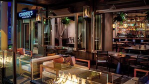 A restaurant with a glass fireplace, seating area, and a bar. - Marriott Indianapolis Downtown (Indianapolis)