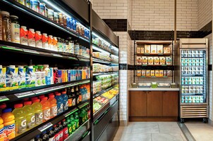 Un negozio di alimentari con scaffali pieni di bevande e prodotti confezionati.