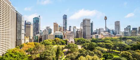 A cityscape with modern high-rise buildings and a park area with pathways and trees.