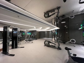 Un gimnasio moderno con cintas de correr, elípticas y equipo de levantamiento de pesas.