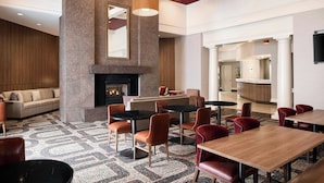 A modern hotel lobby with a fireplace, seating area, and a bar. - Residence Inn by Marriott Charlotte Uptown (Charlotte)