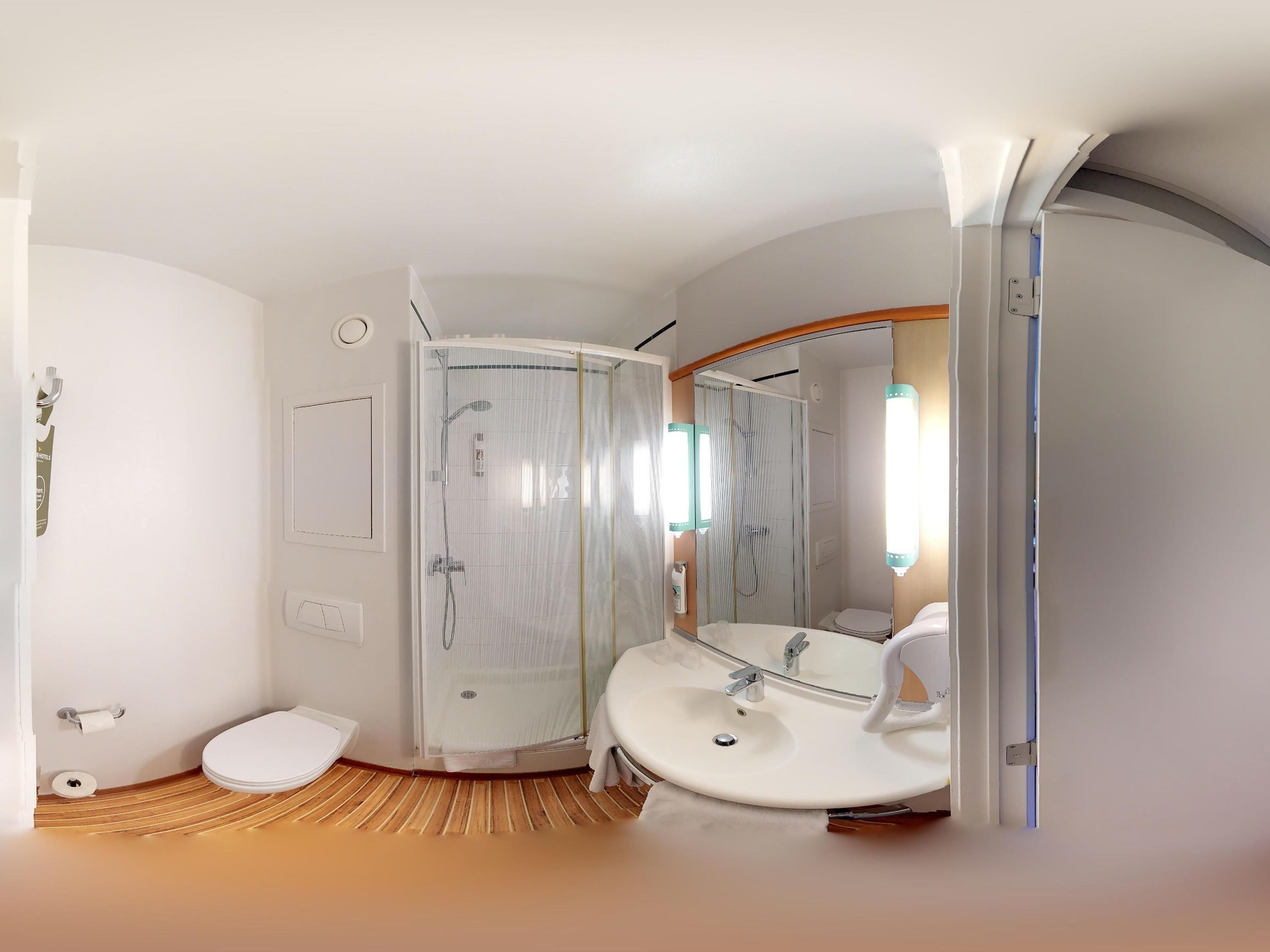 Un baño moderno con ducha, inodoro y lavabo.