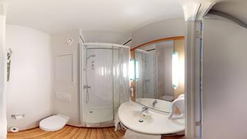 Une salle de bain moderne équipée d’une douche, de toilettes et d’un lavabo.