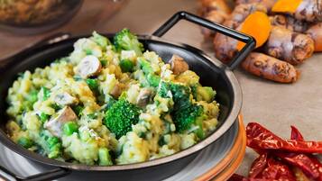 A pan of mixed vegetables with a handle, surrounded by whole spices.