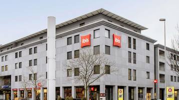 A modern building with multiple 'ibis' signs, indicating a hotel or similar establishment.