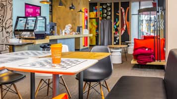 A modern cafe with a wooden counter, tables, and chairs, and a coffee cup on a table.