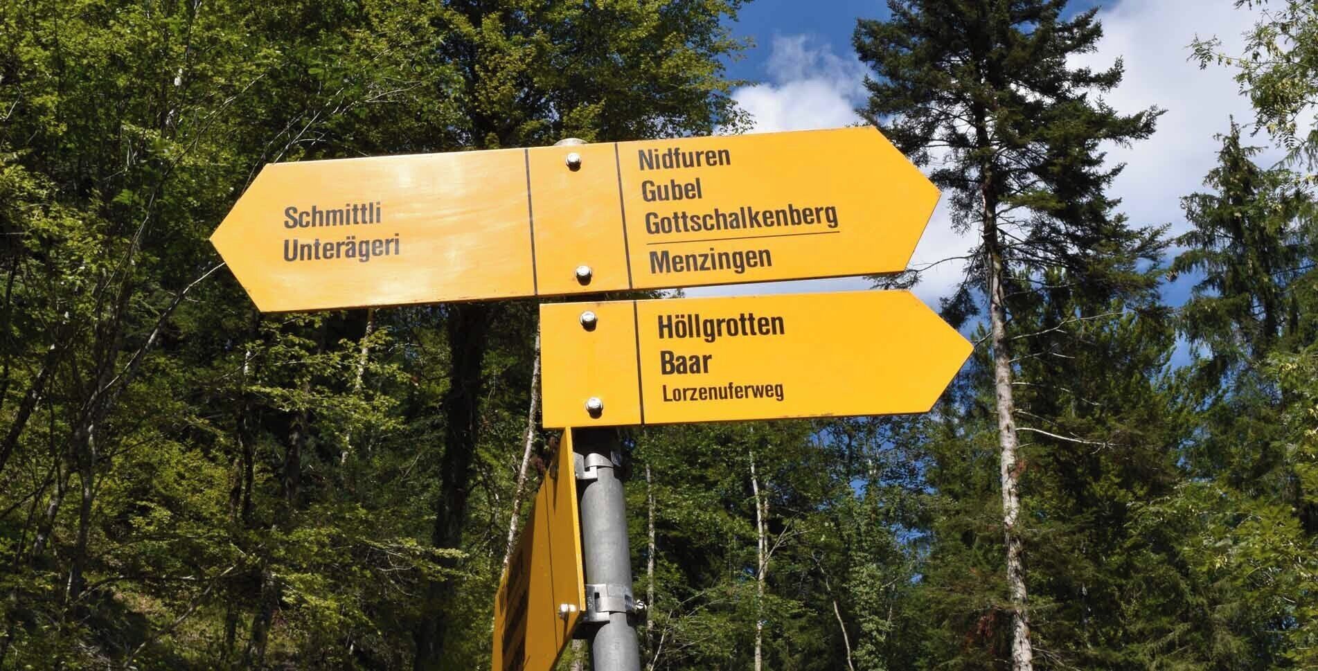 A directional signpost with multiple arrows pointing towards various destinations.