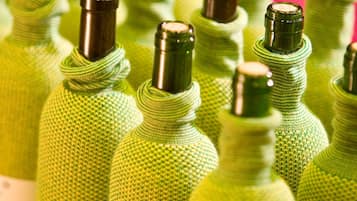 A collection of green wine bottles with labels, arranged closely together.