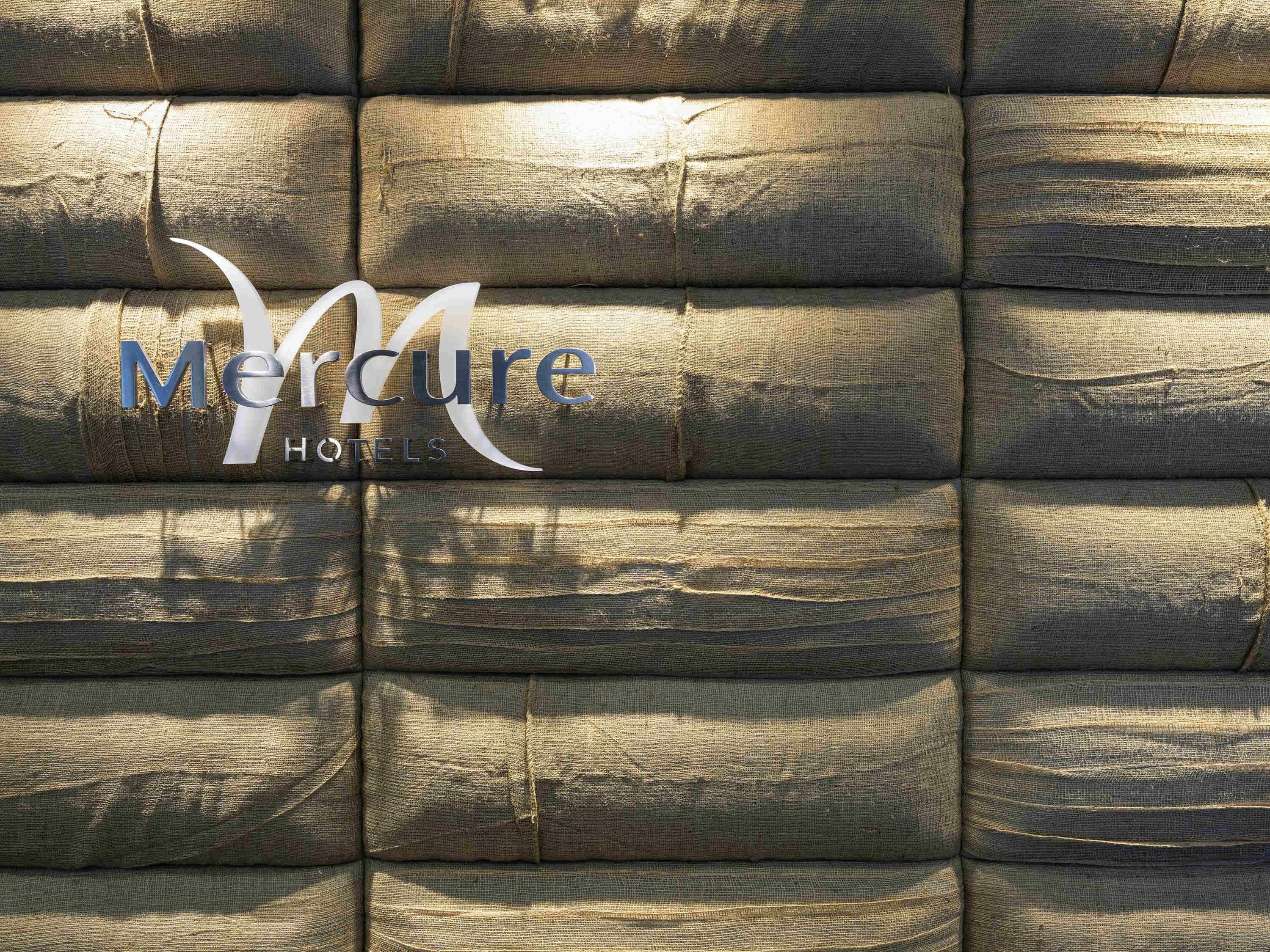 A textured wall with the 'Mercure Hotels' logo.